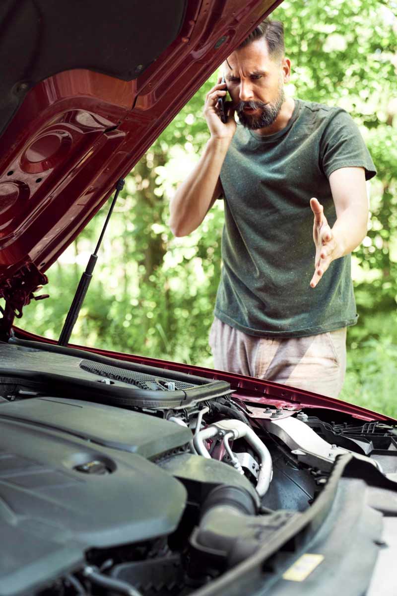 Junger Mann prüft Getriebeschaden bei Schrottauto Ankauf Stormarn